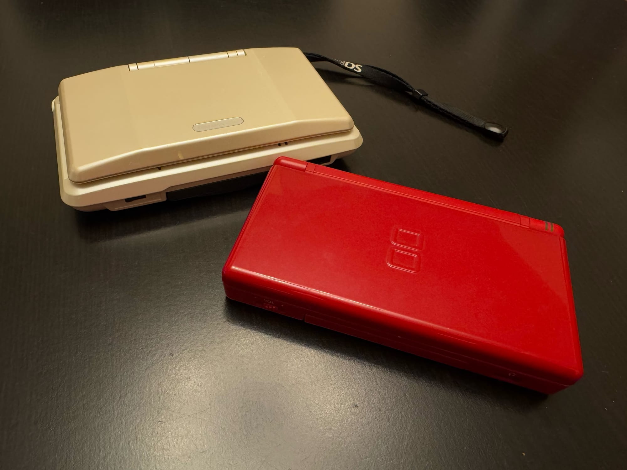 The original Nintendo DS model and the Nintendo DS Lite photographed on a table.