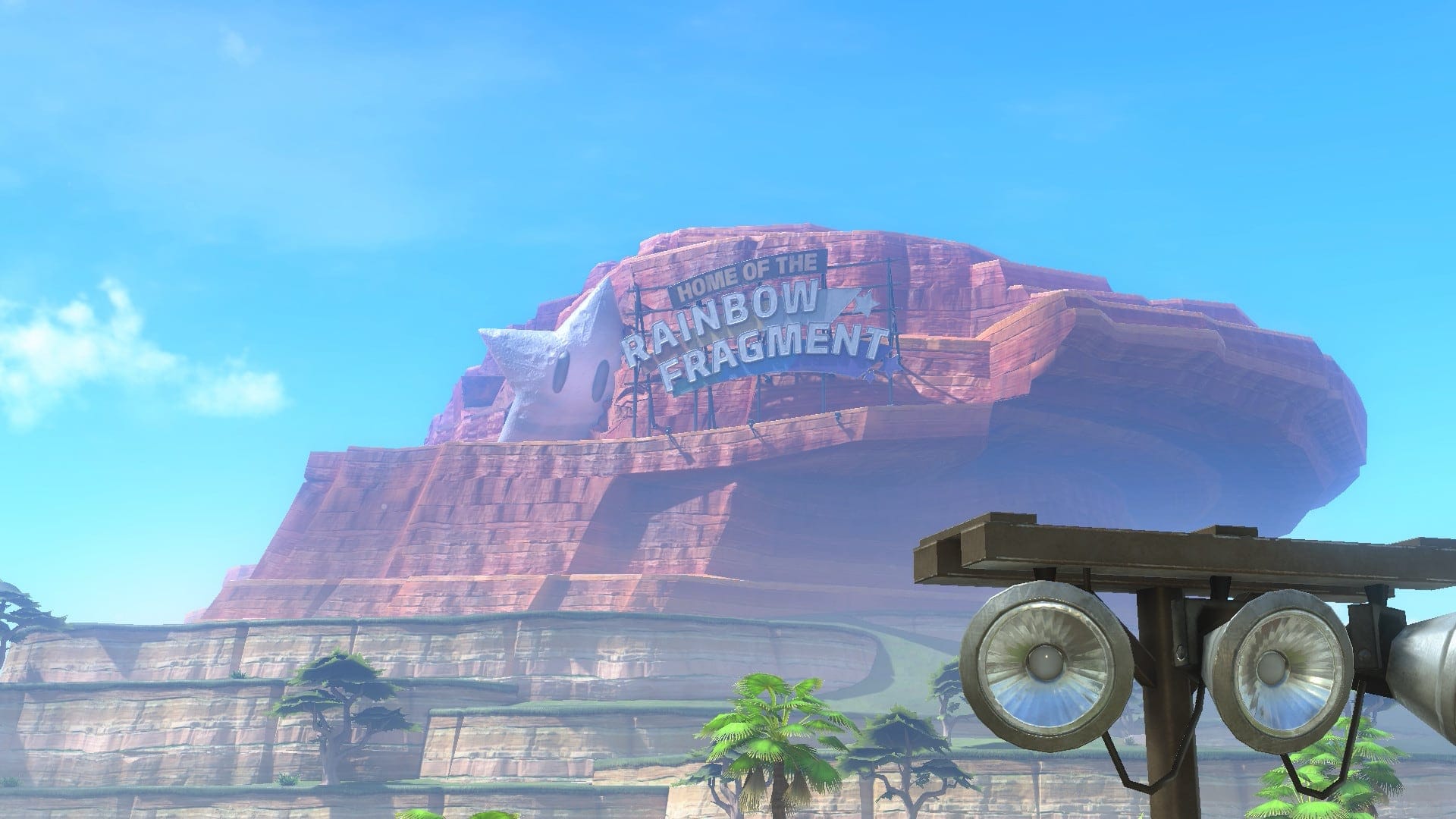 A large sign on a mountain says "Home of the Rainbow Fragment."