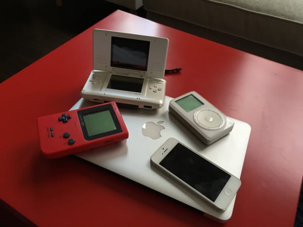 An Apple iPhone, MacBook Pro and iPod next to a Nintendo Game Boy Pocket and Nintendo DS.