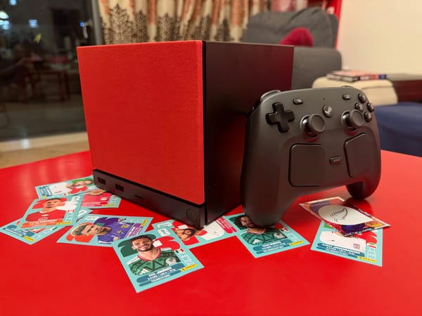 Steam Machine and Steam Controller on a table full of World Cup stickers.